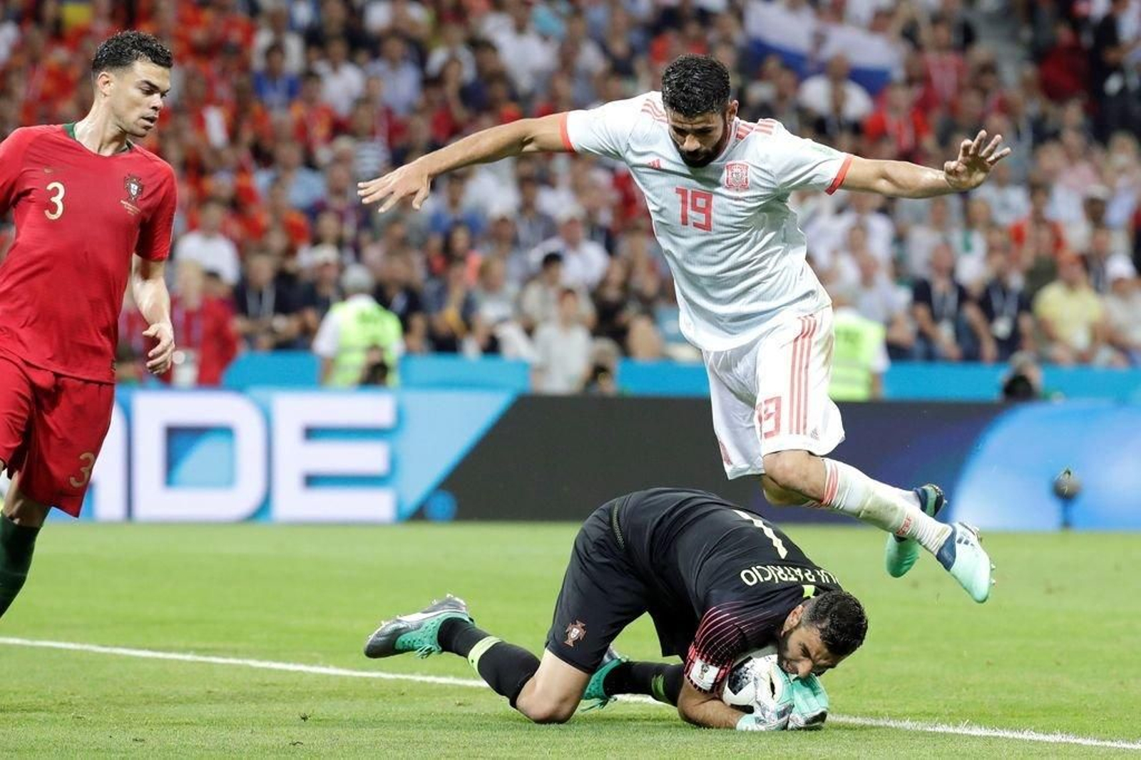 Rui Patricio recoge el balón ante la presión de Diego Costa.