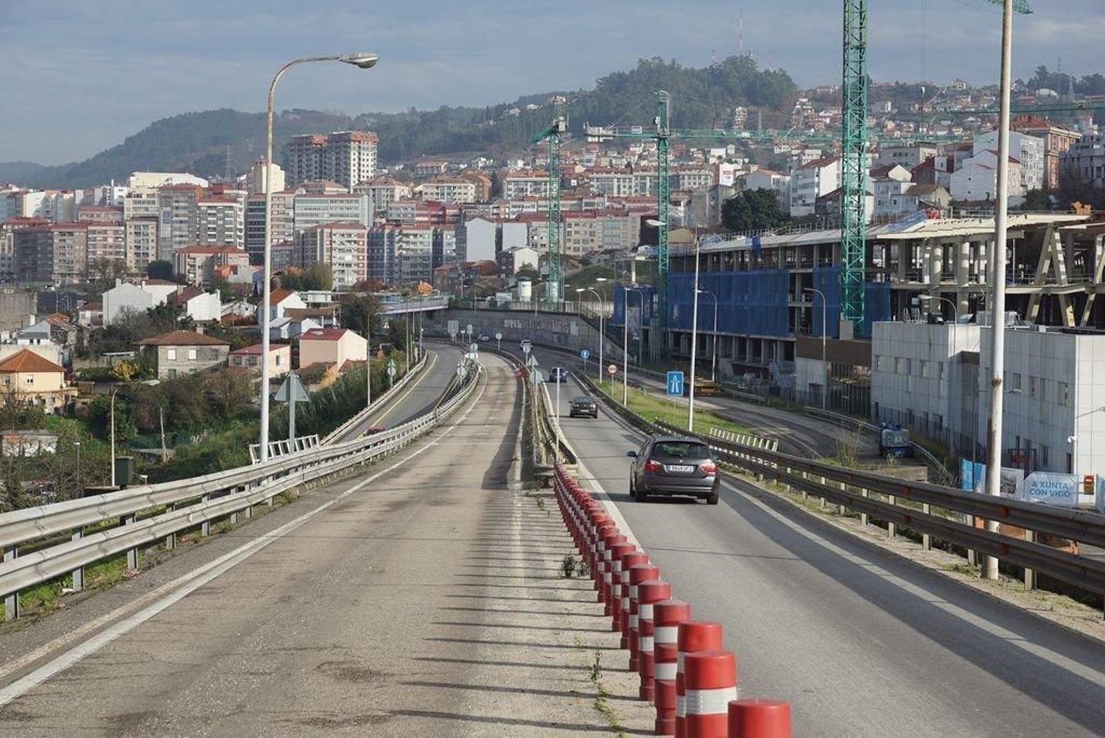 Vehículos entrando en la AP-9 desde la calle Lepanto, donde se construye el complejo ferroviario, de autobuses y comercial