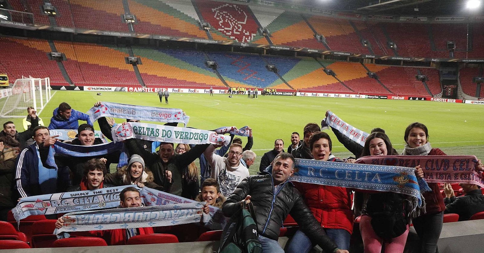 Un grupo de aficionados del Celta, ayer en el Amsterdam Arena durante el entrenamiento del equipo de Eduardo Berizzo, al fondo de la imagen. // JV Landín