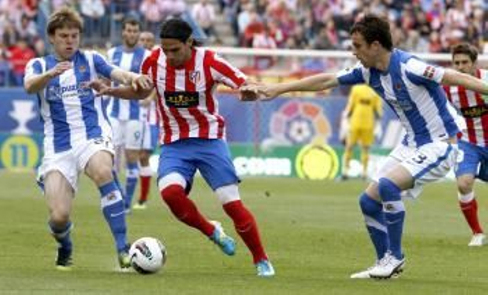 El delantero colombiano del Atlético de Madrid Radamel Falcao (c) controla la pelota ante la presencia de los jugadores de la Real Sociedad Mikel González  (Foto: EFE)