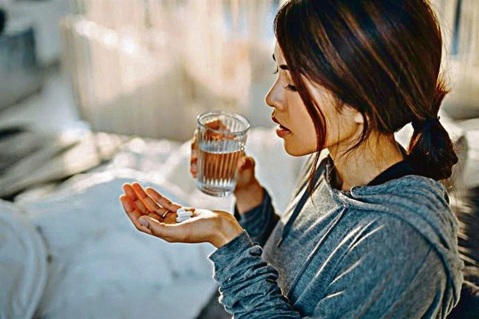 Una mujer tomando medicamentos.