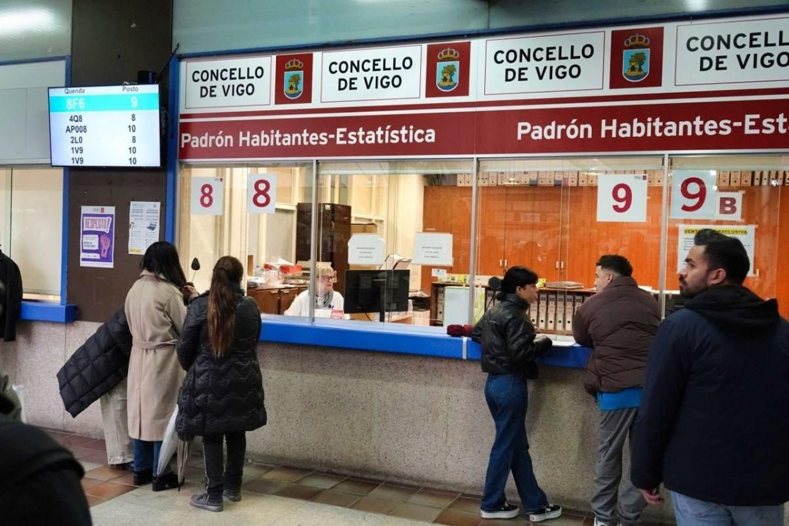 Personas realizando trámites para el padrón en la lonja del Concello.