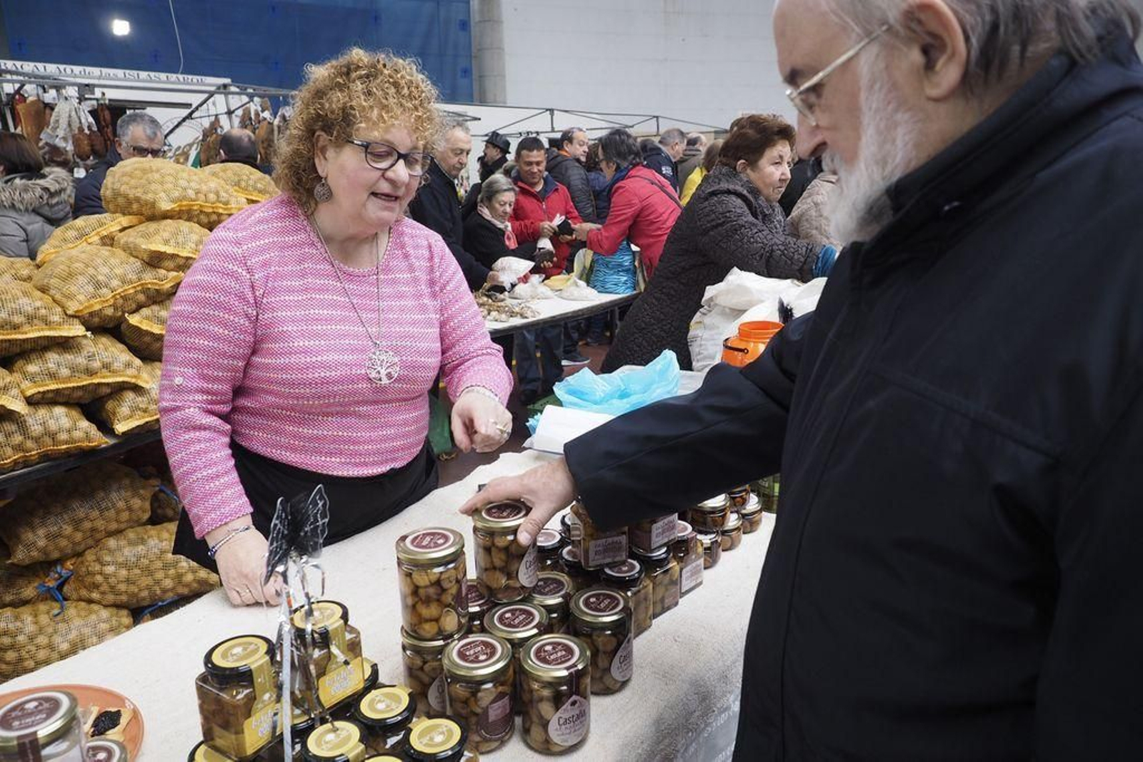 Una productora conversa con un cliente en la feria de Monterroso.