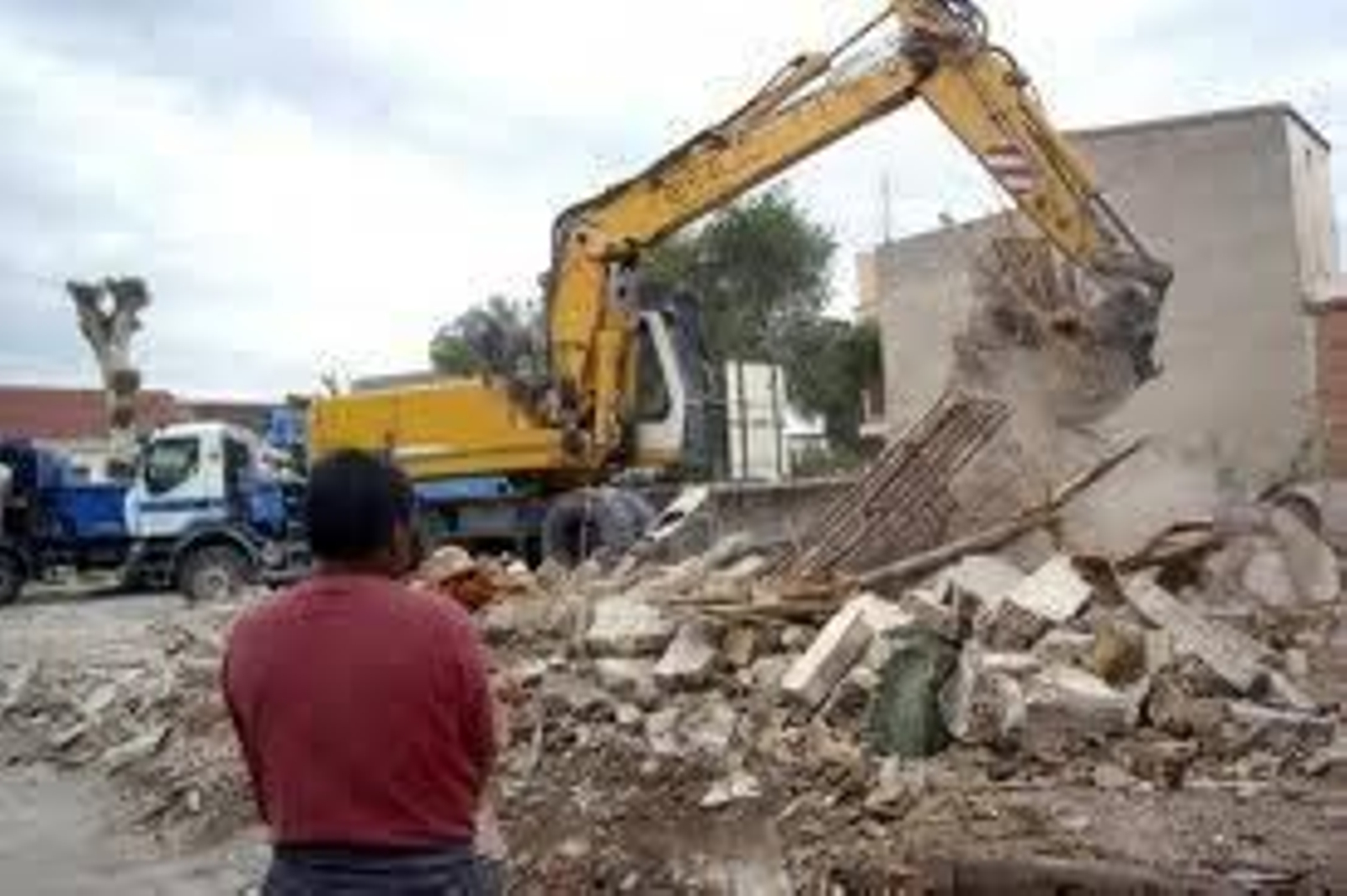 En la imagen, una pala retira escombro.