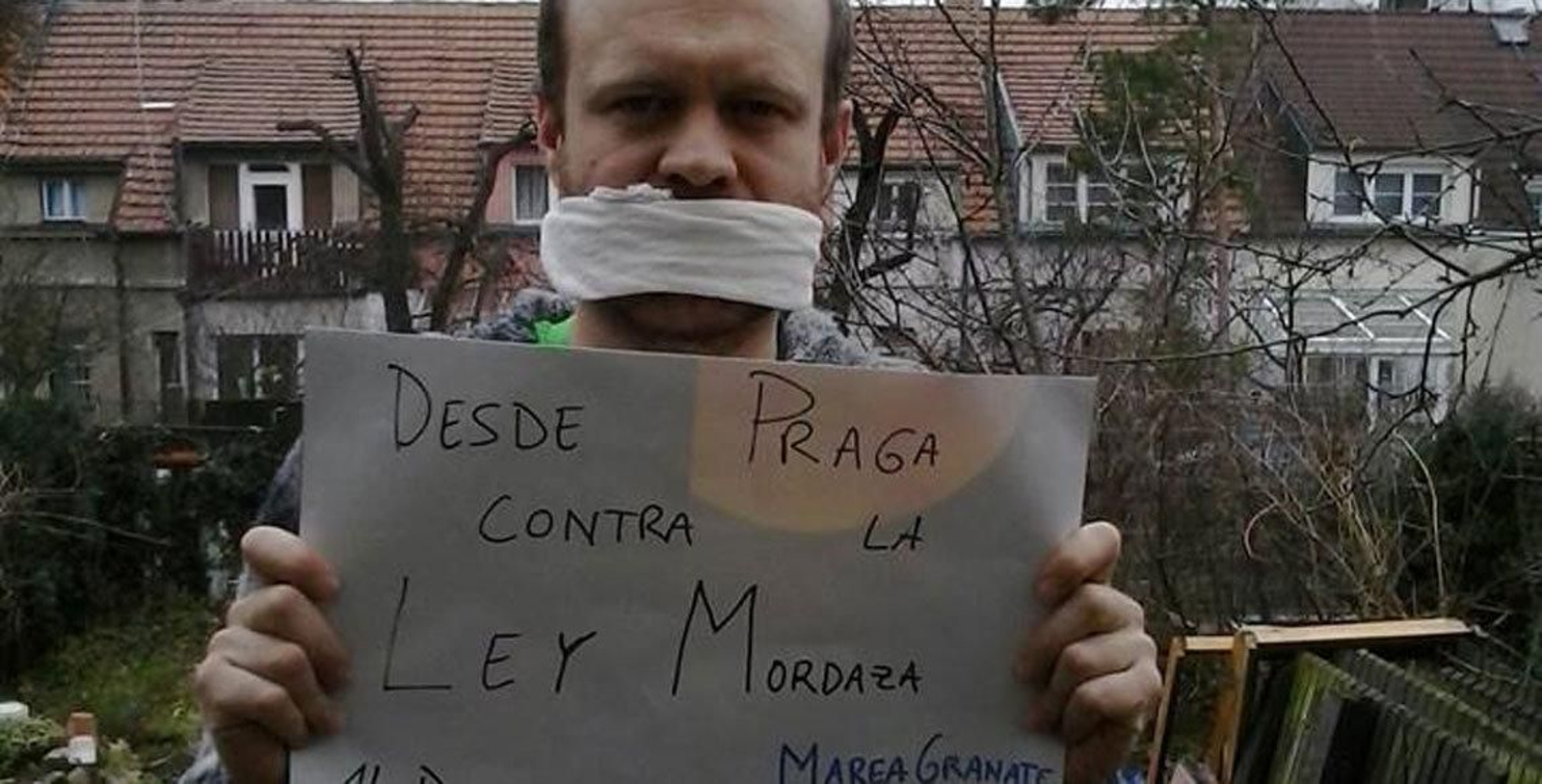Un joven muestra un cartel, desde Praga.