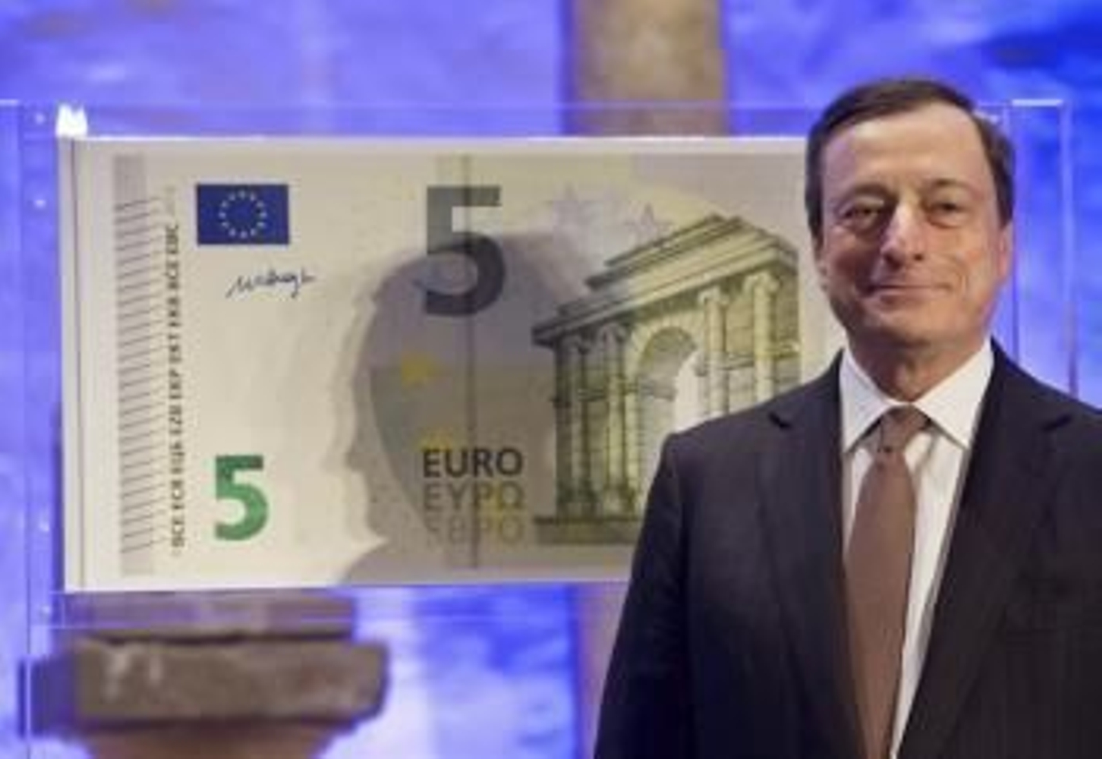 El presidente del Banco Central Europeo (BCE), Mario Draghi, posa al lado de una copia a tamaño gigante del nuevo billete de cinco euros