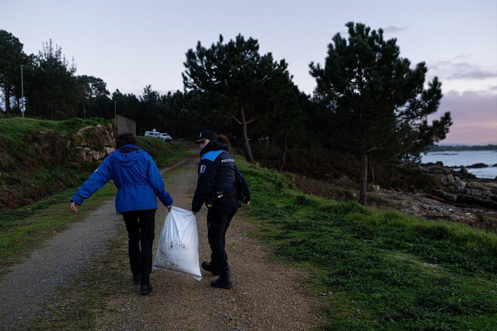La Policía retira un saco de plásticos de una playa de A Illa de Arousa. // E.P.