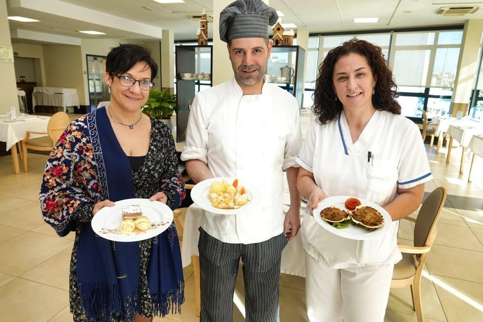 Miguel Tascón, junto con su equipo de cocina, muestran los platos navideños de la residencia Domusvi.