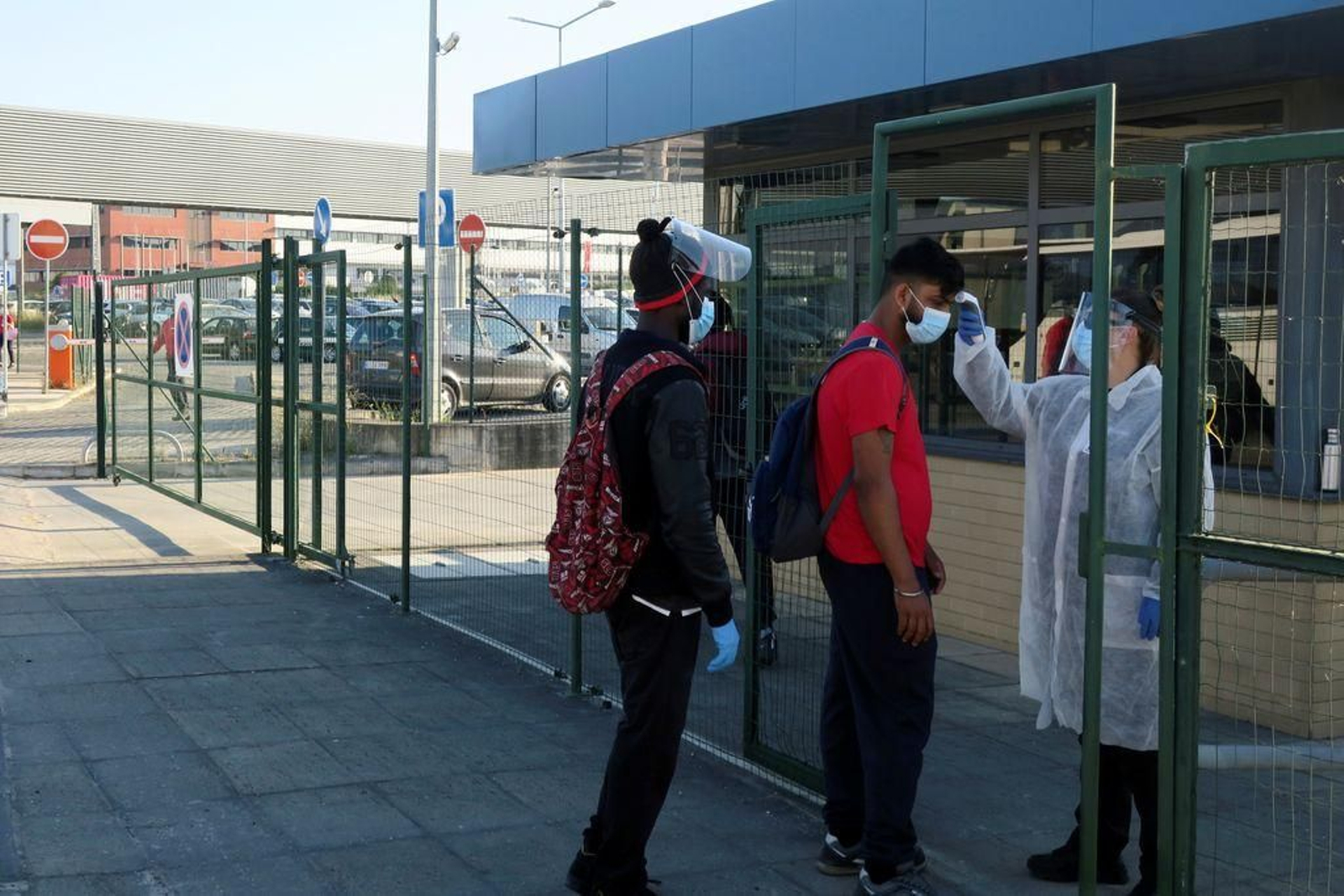 Una persona toma la temperatura a dos trabajadores en Lisboa.