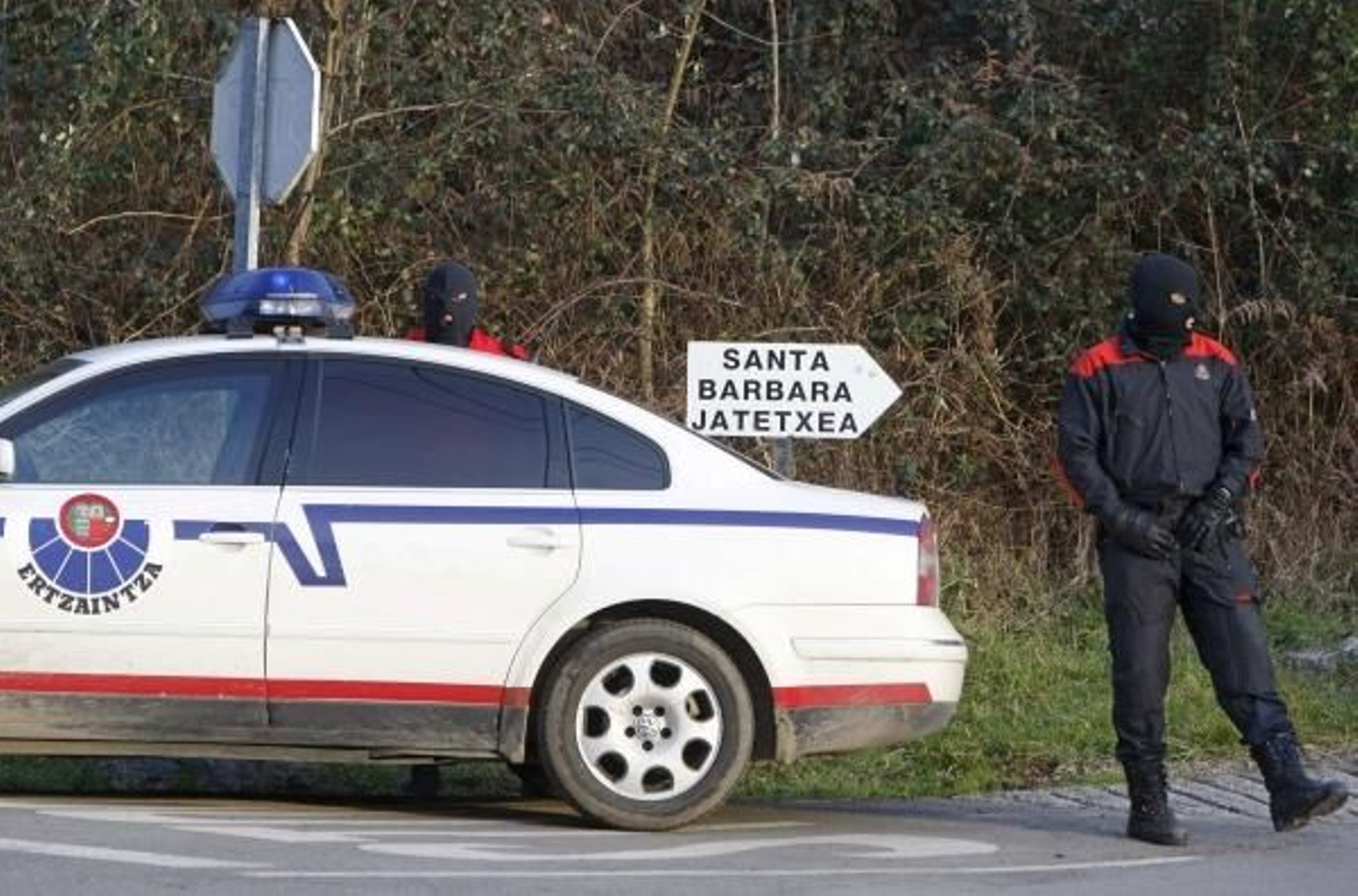 Un Ertzaintza vigila la carretera de acceso al repetidor. (Foto: Juan Herrero)