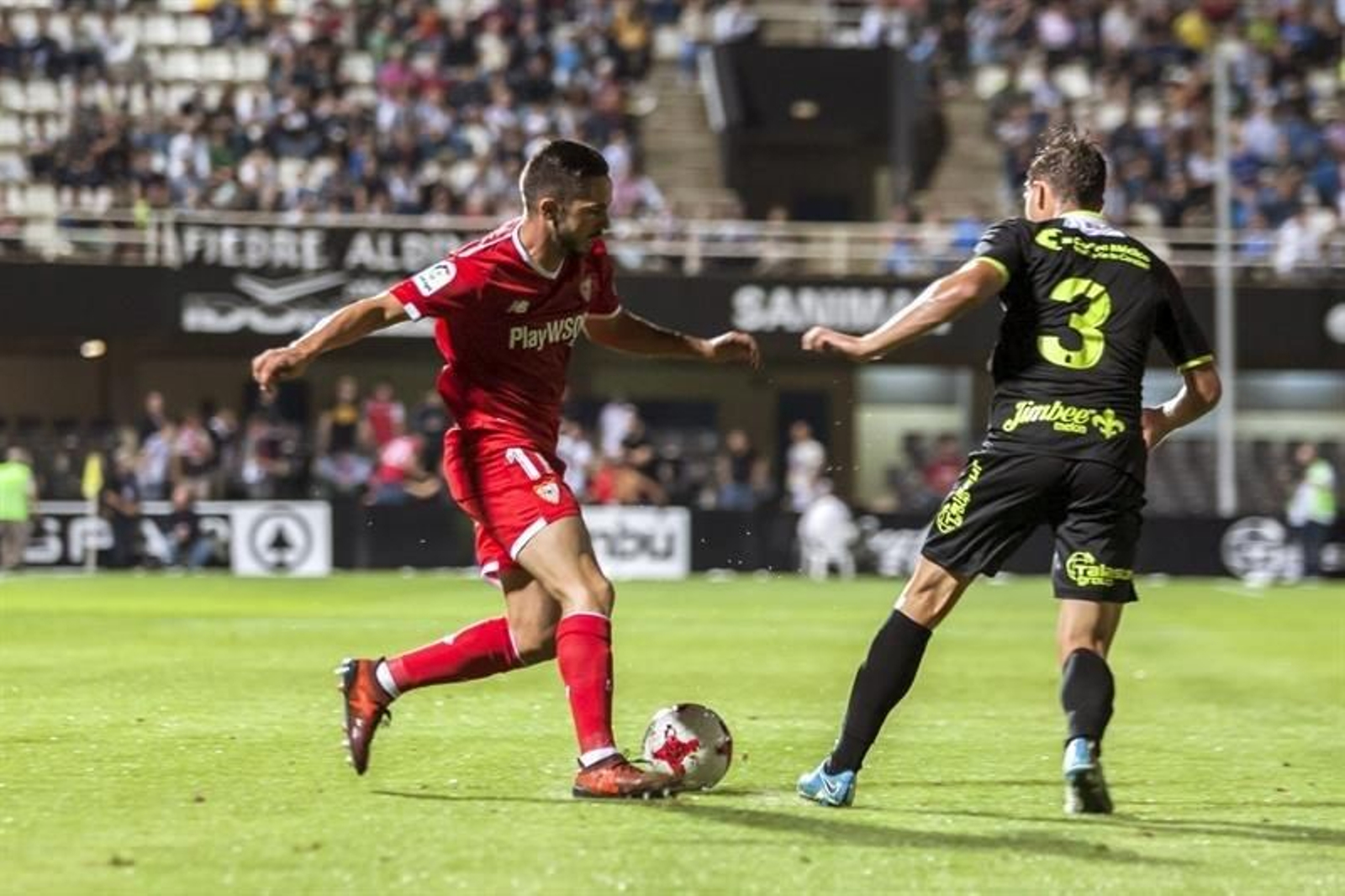 El delantero argentino del Sevilla FC Joaquín Correa (i) lucha el balón con Morros, del Cartagena