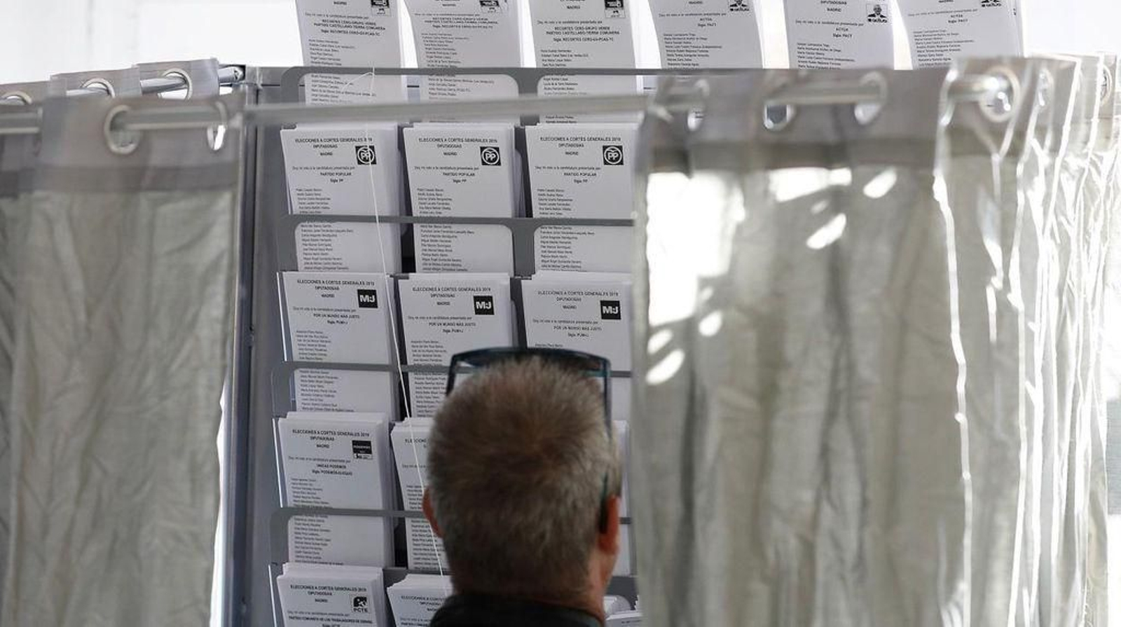 Un hombre observa las papeletas en un colegio electoral.