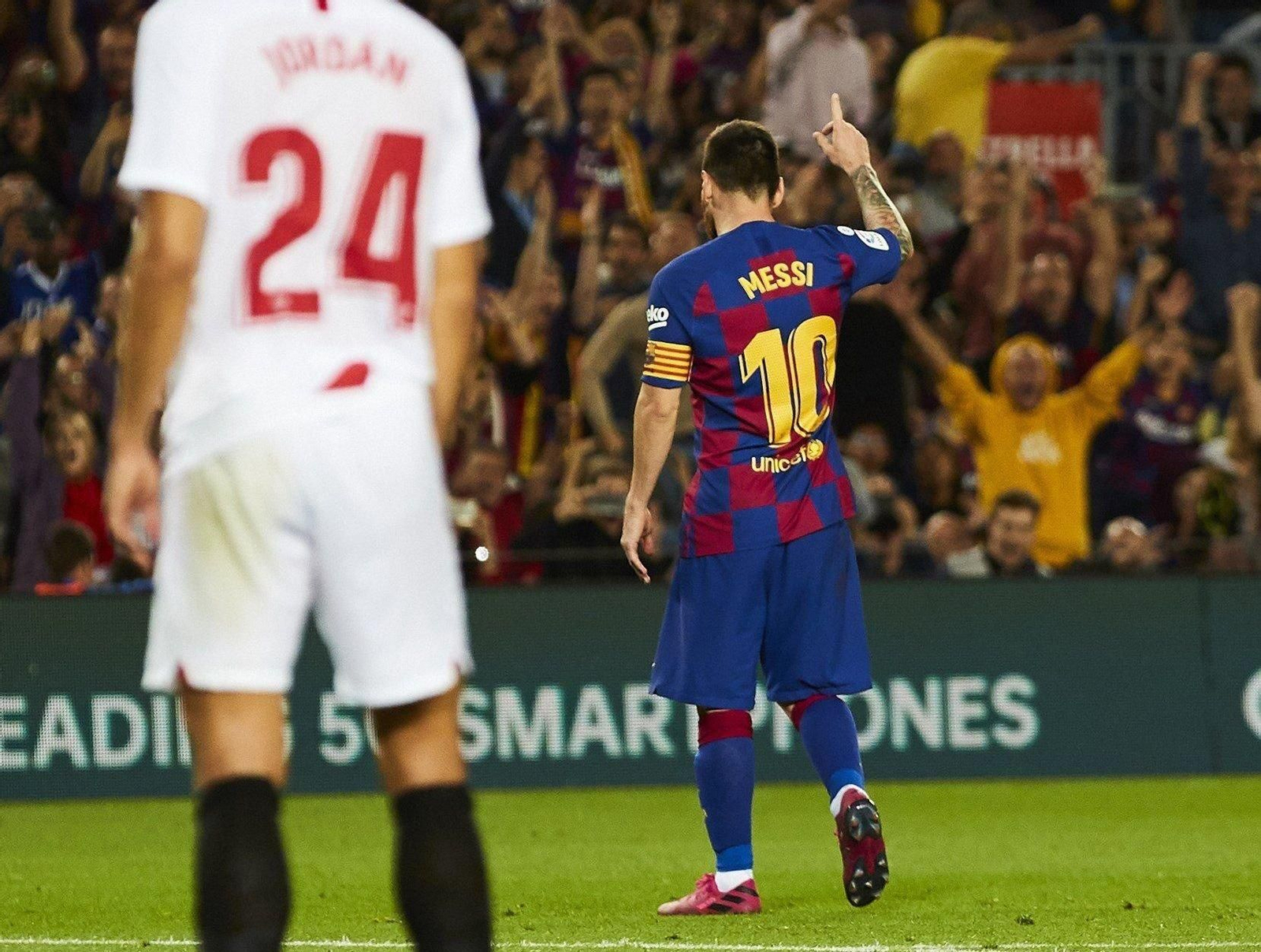 Messi celebra su gol ante la mirada de Joan Jordán.