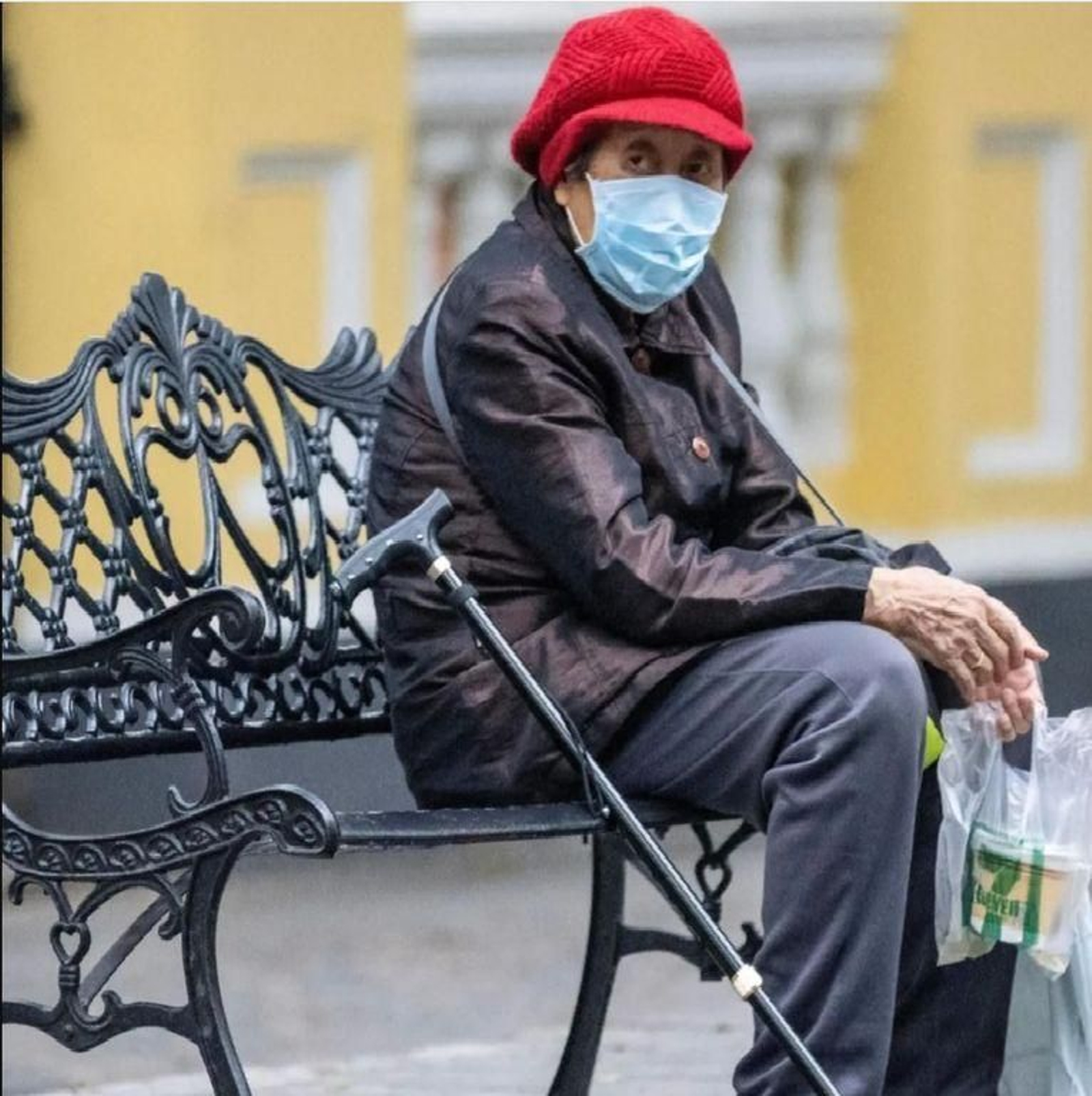 Un persona mayor sentada en un banco de Tarragona.
