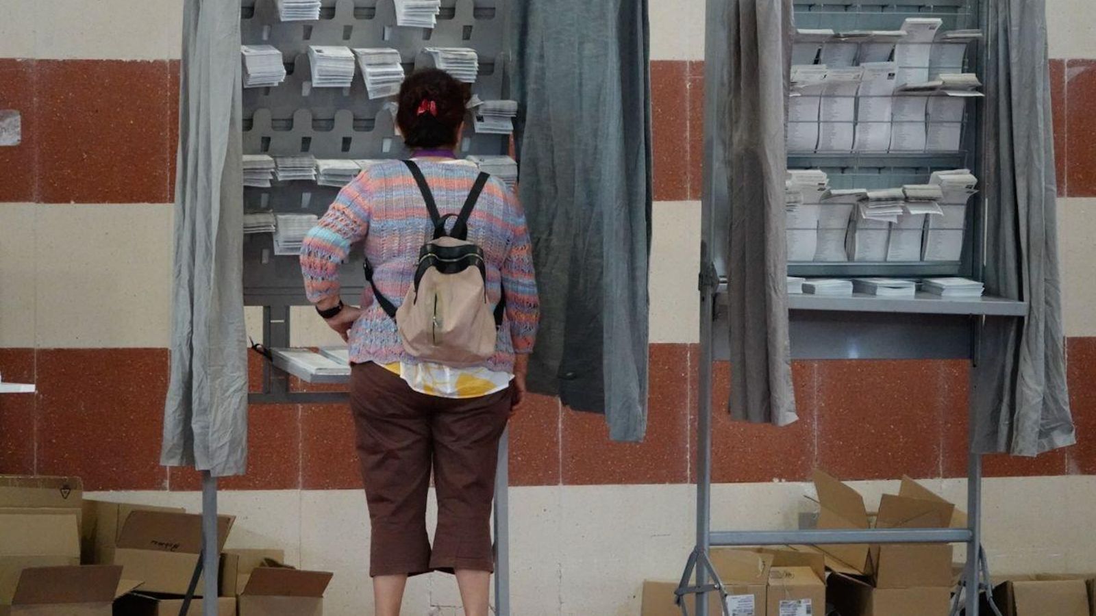 Una mujer revisa en un colegio electoral de Vigo todas las opciones para votar en estas elecciones europeas. // Vicente Alonso