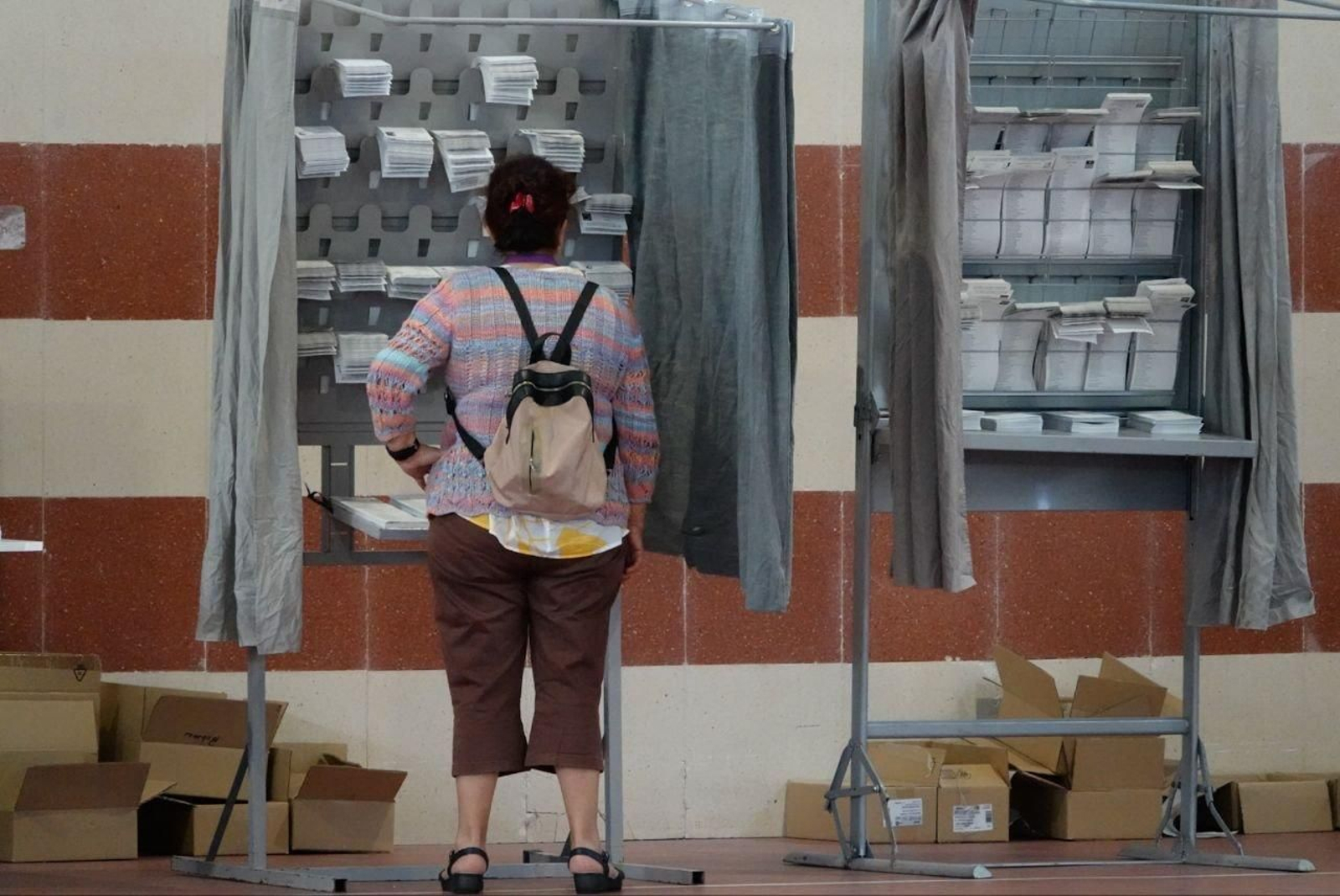 Una mujer revisa en un colegio electoral de Vigo todas las opciones para votar en estas elecciones europeas. // Vicente Alonso