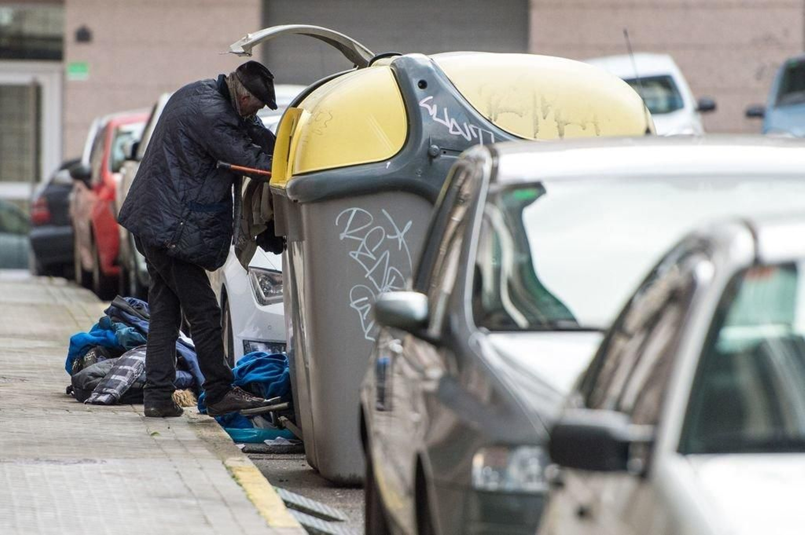 Una persona rebusca en los contenedores de basura en Ourense.