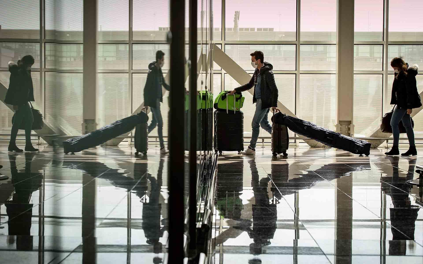 Archivo. Varios pasajeros protegidos con mascarillas en el aeropuerto de Barcelona. EFE/Enric Fontcuberta