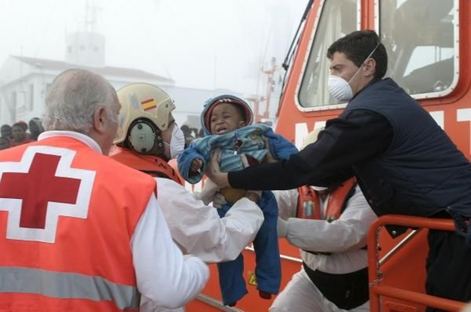 Un niño es recogido por miembros de la Cruz Roja. (Foto: Paquet)