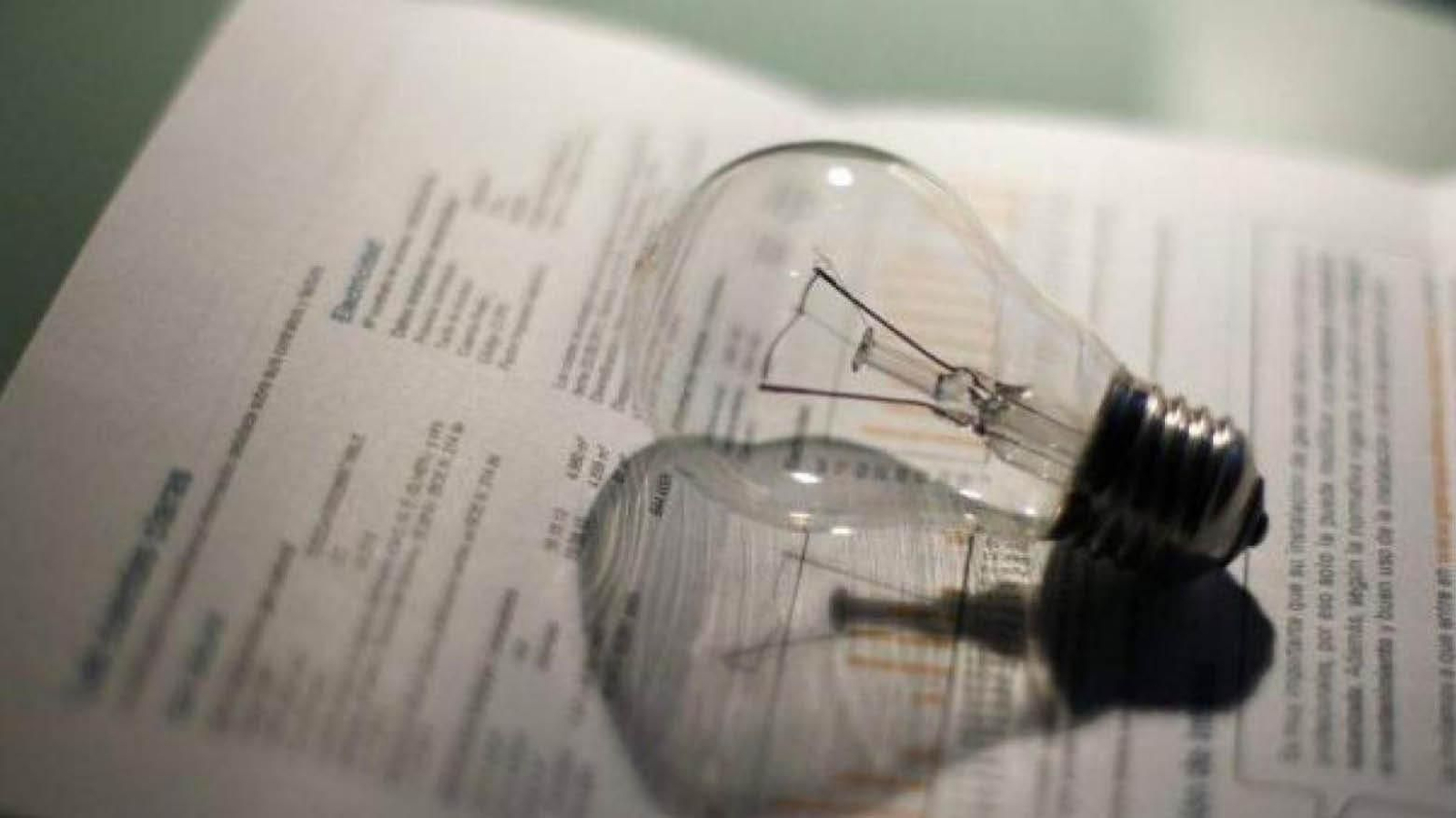 Una bombilla reposa sobre una factura de la luz emitida para un hogar español.