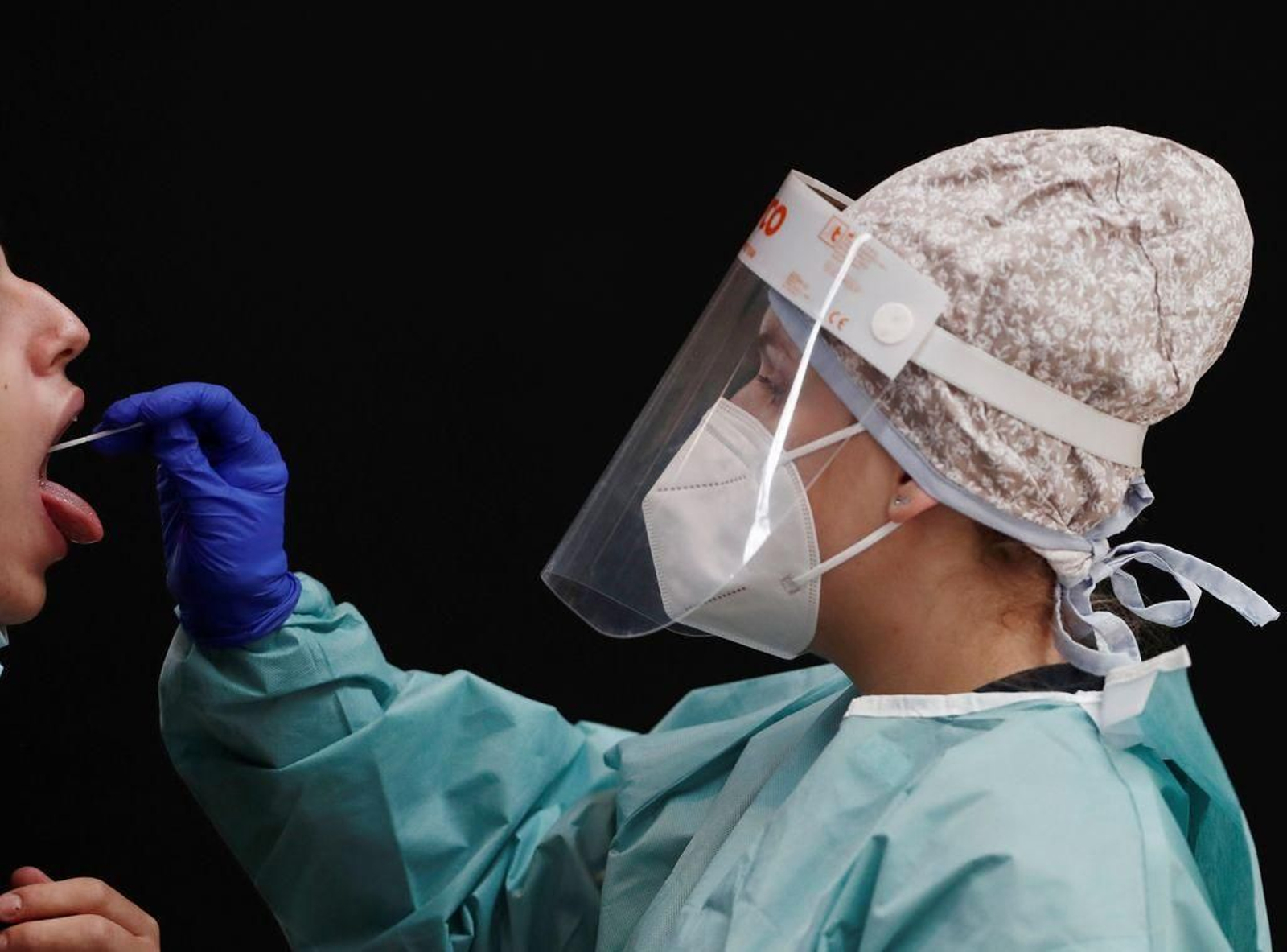 Una enfermera toma muestras a una joven para una prueba PCR, en Pamplona.