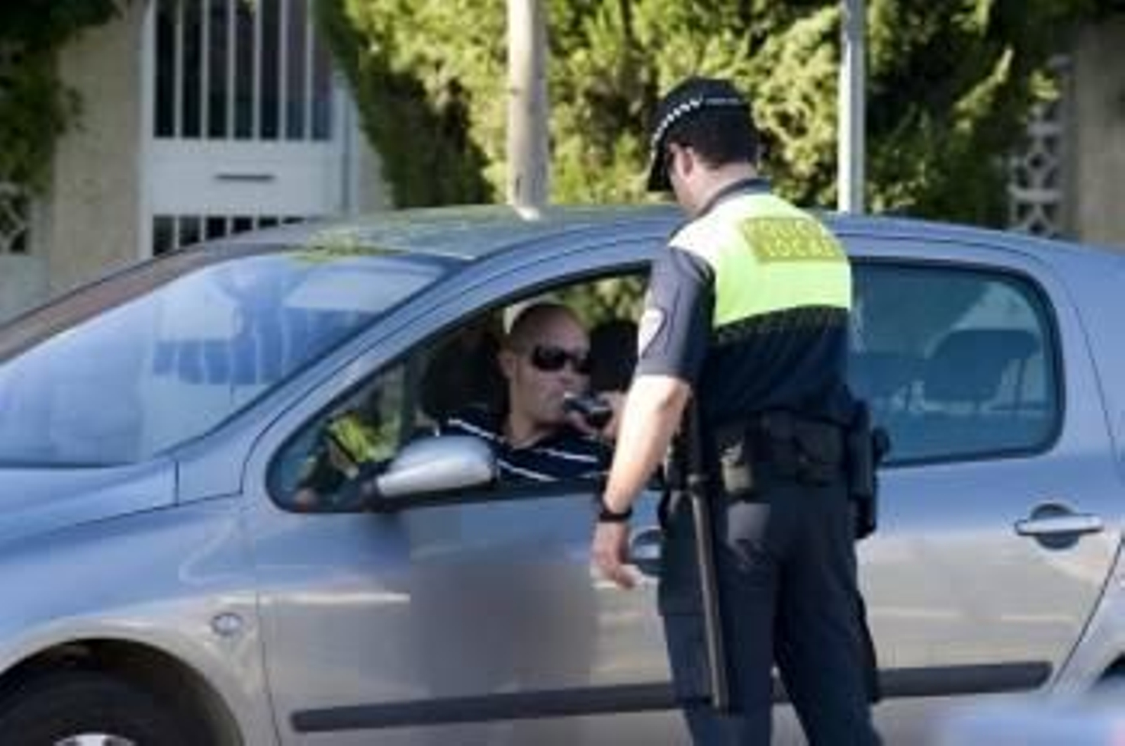 Un agente de policía local realiza un control de alcoholemia a un conductor en una vía urbana. (Foto: ARCHIVO )