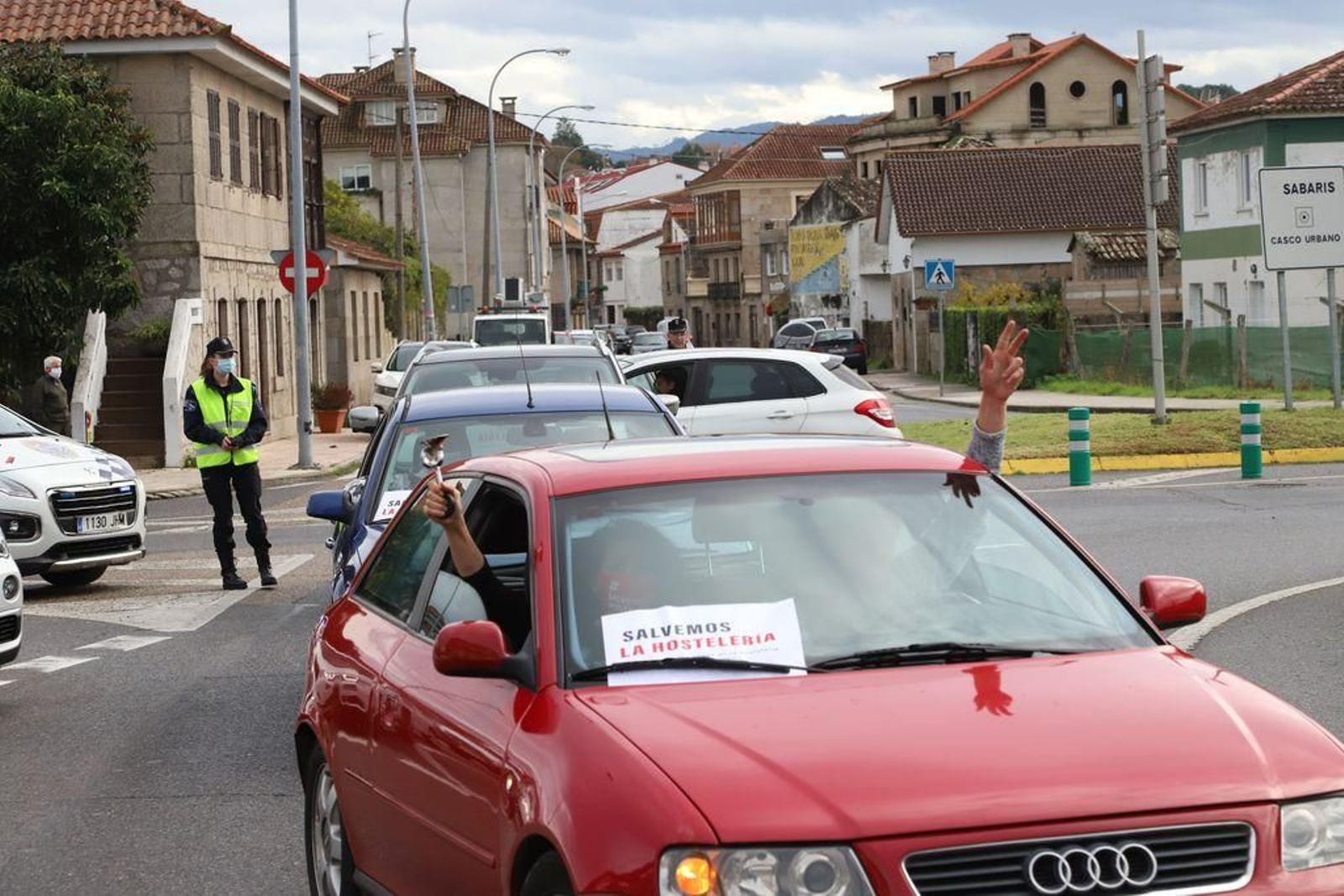 La caravana de coches a su paso por la rotonda baionesa de Santos Peralba escoltada por agentes de la autoridad.