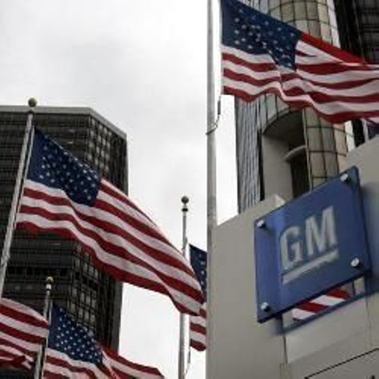 Tres banderas estadounidenses ondean junto a un cartel de GM.