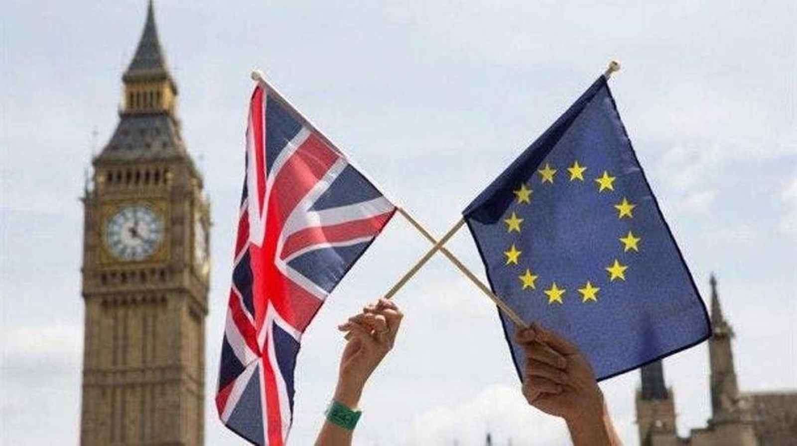 Dos personas sostiene la bandera del Reino Unido y de la Unión Europea en Londres.