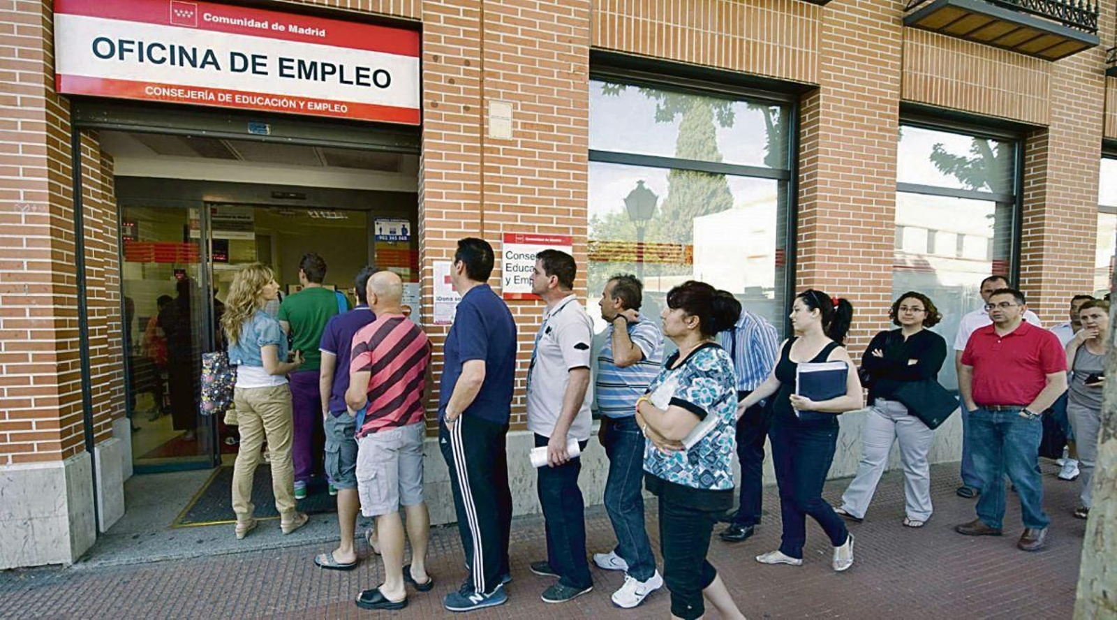 Un grupo de desempleados guarda cola en una oficina de empleo madrileña.