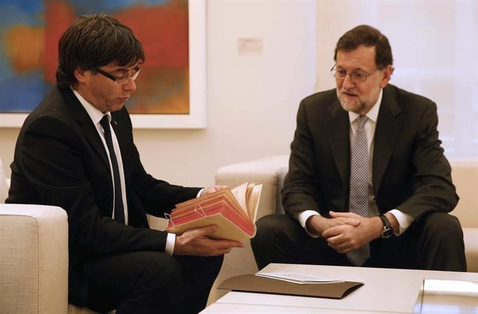El presidente del Gobierno en funciones, Mariano Rajoy (d) tras regalarle un facsímil de El Quijote al presidente de la Generalitat, Carles Puigdemont