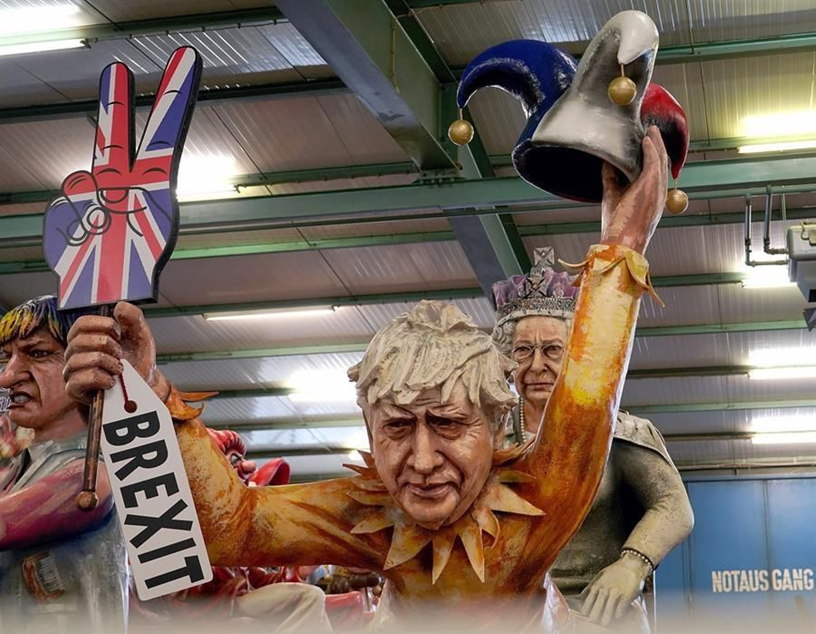 Una figura del Carnaval de Mainz presenta al primer ministro británico Boris Johnson con un letrero de Brexit y un sombrero  agachado frente a la Reina