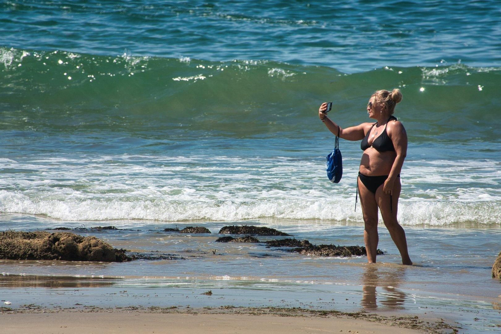 Una mujer se toma un selfie en Samil.