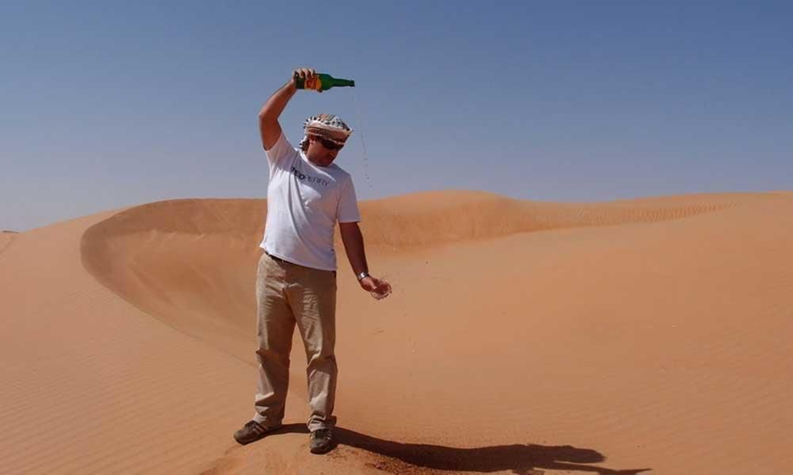 Carlos Alejandre escancia un "culín" de sidra en Omán, en pleno desierto.