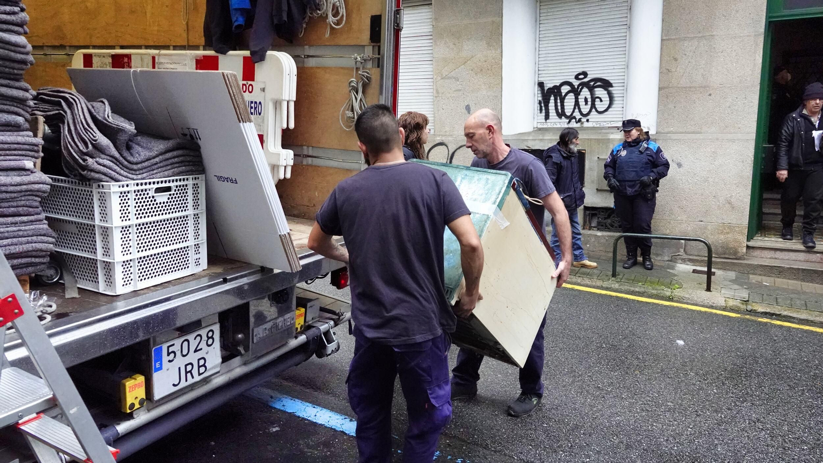 Dos trabajadores de una empresa de mudanzas colocan en el camión los enseres de los vecinos desalojados.